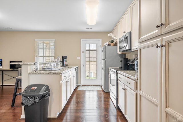 62 Squire Cir, Lynchburg, VA 24501 - kitchen with appliances with stainless steel finishes, a sink, a kitchen bar, dark wood finished floors, and light stone counters