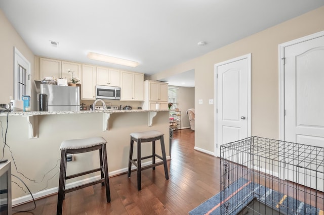 62 Squire Cir, Lynchburg, VA 24501 - kitchen with stainless steel appliances, dark wood-style floors, light stone counters, and a kitchen bar
