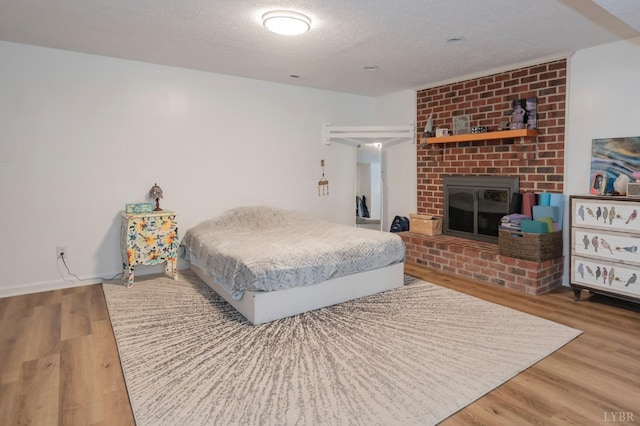 220 Swan Ln, Forest, VA 24551 - bedroom with a textured ceiling, wood finished floors, and a fireplace