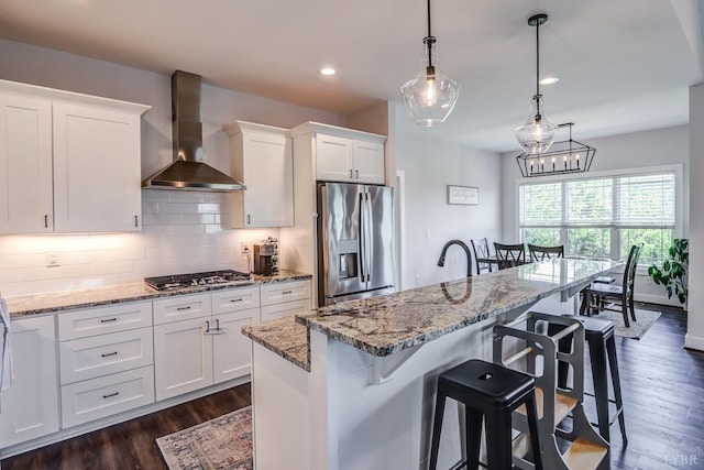 1151 Jefferson Meadows Dr, Forest, VA 24551 - kitchen with stainless steel appliances, wall chimney range hood, white cabinetry, dark wood-style floors, and a kitchen bar