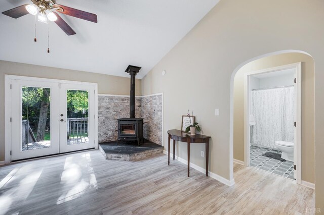 9790 Bear Creek Rd, Gladys, VA 24554 - living area with lofted ceiling, wood finished floors, a wood stove, arched walkways, and french doors
