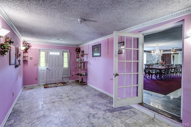 foyer entrance with ornamental molding, a chandelier, and a textured ceiling