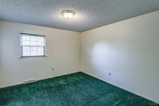 carpeted spare room with a textured ceiling and baseboards