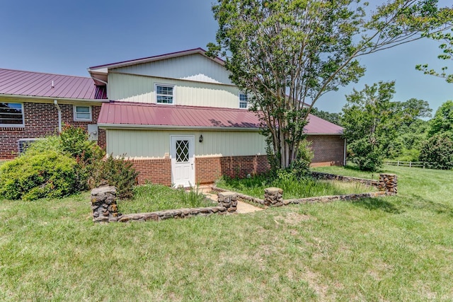 view of side of home with brick siding and a metal roof
