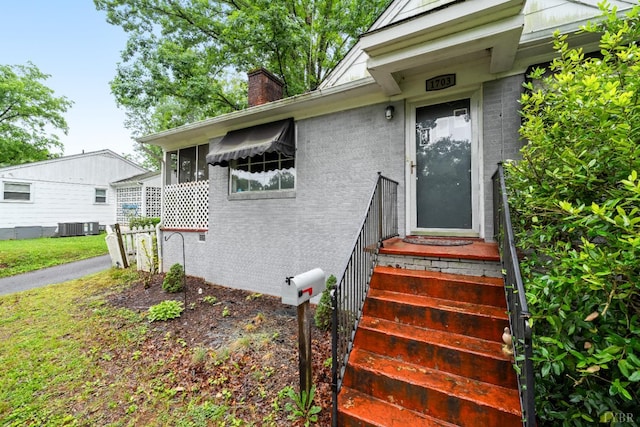 1703 Dale Ave, Altavista, VA 24517 - property entrance featuring a chimney, brick siding, and cooling unit