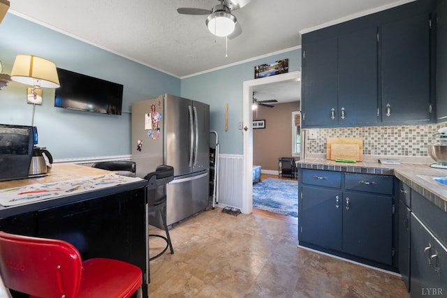 1703 Dale Ave, Altavista, VA 24517 - kitchen with a ceiling fan, freestanding refrigerator, crown molding, backsplash, and blue cabinetry