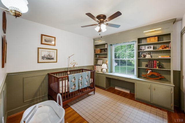 921 Peaksview St, Bedford, VA 24523 - bedroom featuring wainscoting, baseboard heating, a crib, and light wood-style floors