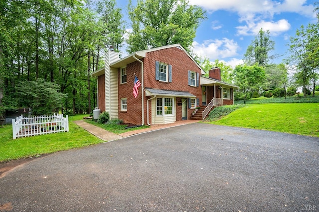 921 Peaksview St, Bedford, VA 24523 - view of front of property with a chimney, brick siding, driveway, and a front lawn