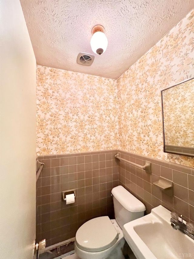 166 Matohe Rd, Monroe, VA 24574 - half bath with wallpapered walls, wainscoting, a textured ceiling, and tile walls
