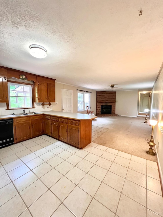 166 Matohe Rd, Monroe, VA 24574 - kitchen with dishwasher, a peninsula, light countertops, brown cabinets, and a fireplace