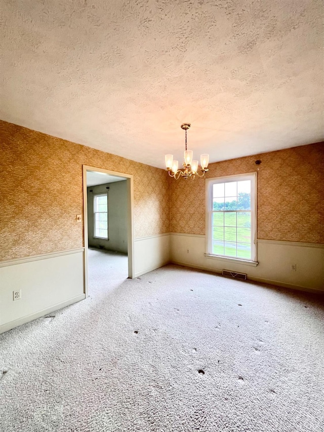 166 Matohe Rd, Monroe, VA 24574 - spare room featuring wallpapered walls, a chandelier, carpet flooring, and a textured ceiling