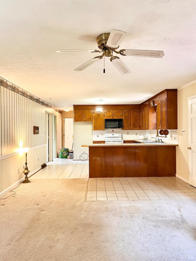 166 Matohe Rd, Monroe, VA 24574 - kitchen featuring light tile patterned flooring, black microwave, a peninsula, light colored carpet, and brown cabinets