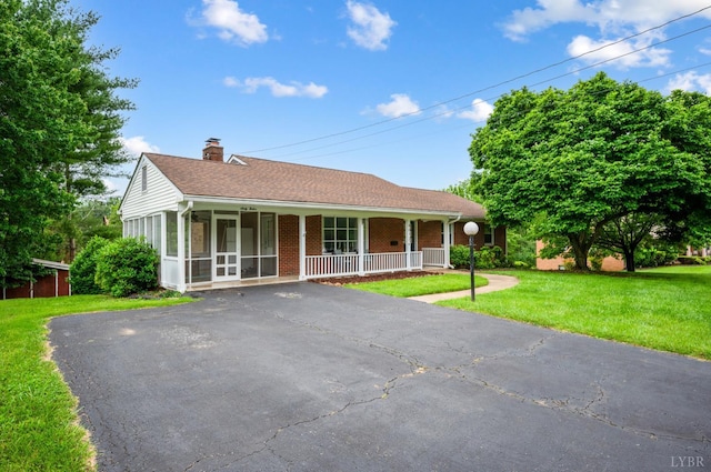 6012 Rhonda Rd, Lynchburg, VA 24502 - ranch-style home featuring a chimney, a front lawn, brick siding, covered porch, and asphalt driveway