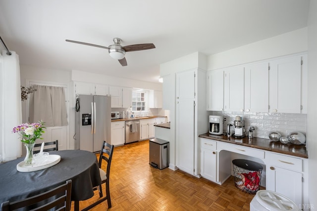 6012 Rhonda Rd, Lynchburg, VA 24502 - kitchen featuring appliances with stainless steel finishes, a ceiling fan, white cabinets, and tasteful backsplash