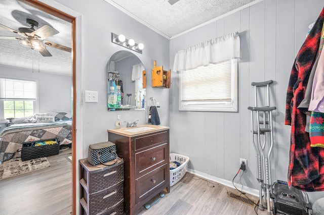 2523 Clarks Rd, Rustburg, VA 24588 - bathroom featuring a textured ceiling, wood finished floors, a ceiling fan, vanity, and crown molding