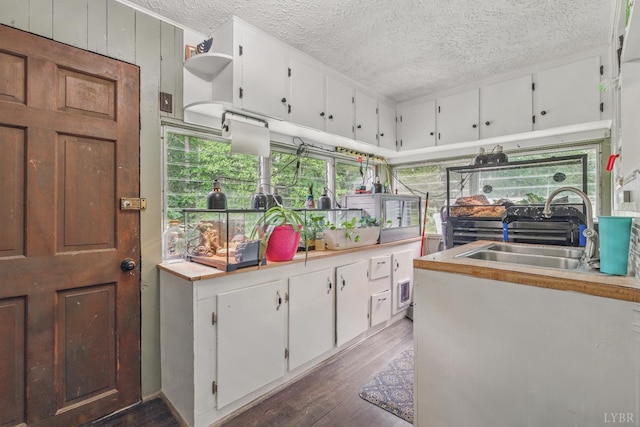 2086 Marshall Mill Rd, Gladys, VA 24554 - kitchen featuring a textured ceiling, white cabinetry, light countertops, wood finished floors, and a sink