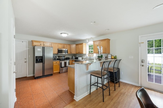 1053 Hupps Hill Ln, Forest, VA 24551 - kitchen featuring appliances with stainless steel finishes, a peninsula, plenty of natural light, light stone counters, and recessed lighting