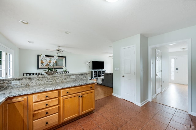 1053 Hupps Hill Ln, Forest, VA 24551 - kitchen with a ceiling fan, tile patterned flooring, brown cabinetry, baseboards, and open floor plan