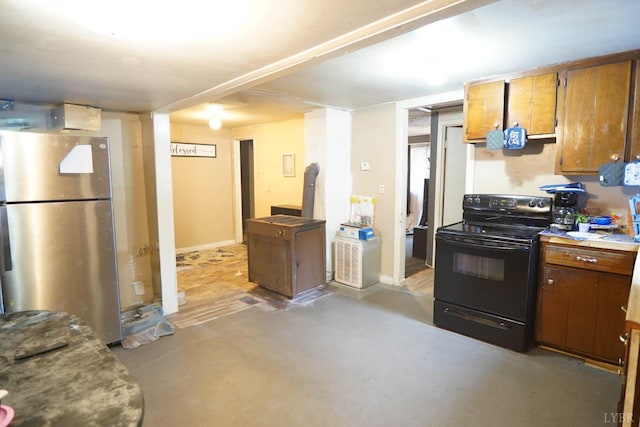 134 Napier Dr, Concord, VA 24538 - kitchen with freestanding refrigerator, black range with electric cooktop, brown cabinetry, and finished concrete floors