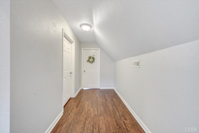 1028 Park Mountain Ter, Huddleston, VA 24104 - corridor featuring dark wood-style flooring, a textured ceiling, lofted ceiling, a textured wall, and baseboards