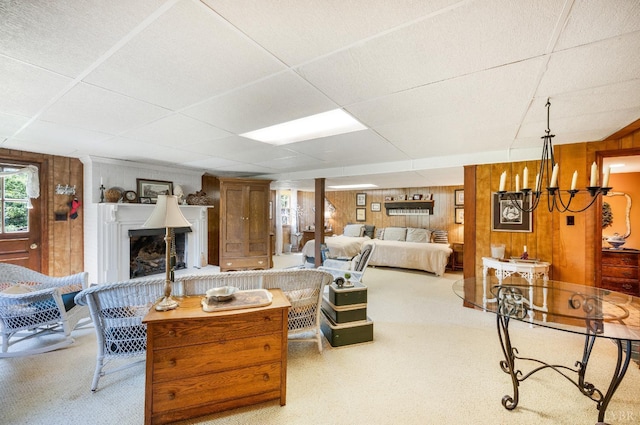1129 Croft Ln, Bedford, VA 24523 - carpeted living area with wood walls, a fireplace with raised hearth, a paneled ceiling, and a chandelier