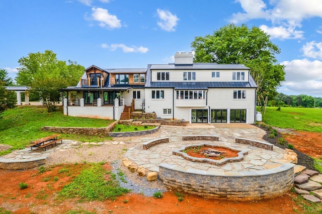 7845 Bear Creek Rd, Gladys, VA 24554 - back of house with an outdoor fire pit, a chimney, a standing seam roof, a metal roof, and stucco siding
