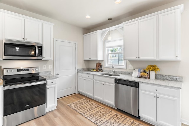 189 Traverse Dr, Evington, VA 24550 - kitchen with stainless steel appliances, light wood finished floors, white cabinets, recessed lighting, and decorative light fixtures