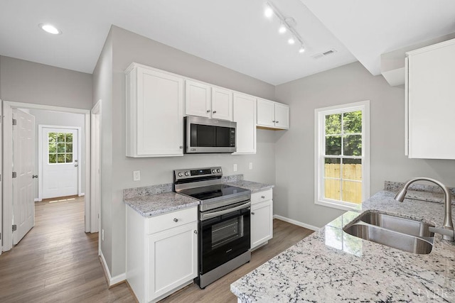 419 Wadsworth St, Lynchburg, VA 24501 - kitchen featuring appliances with stainless steel finishes, light wood finished floors, white cabinetry, light stone countertops, and healthy amount of natural light