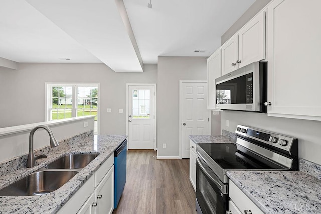 419 Wadsworth St, Lynchburg, VA 24501 - kitchen with appliances with stainless steel finishes, wood finished floors, white cabinetry, and light stone counters