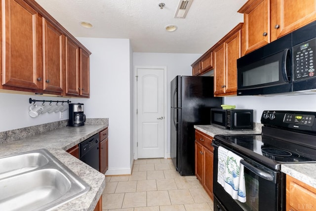 100 Capstone Dr Unit 207, Lynchburg, VA 24502 - kitchen with black appliances, light countertops, brown cabinets, light tile patterned floors, and a textured ceiling