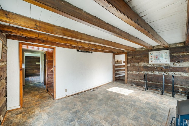 1807 Wheats Valley Rd, Bedford, VA 24532 - unfurnished living room featuring beam ceiling, baseboards, and wood walls