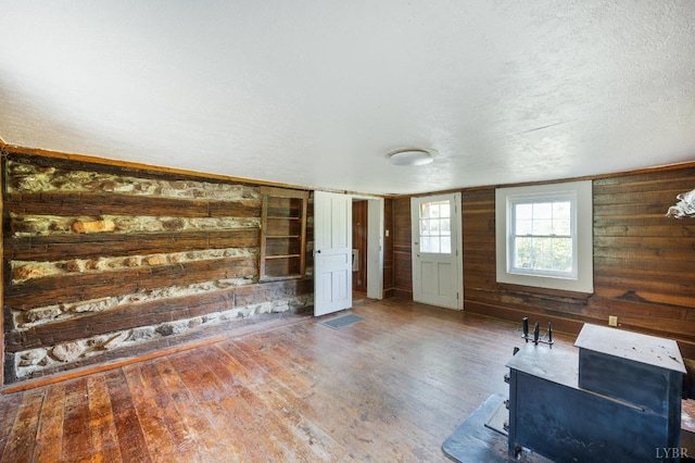 1807 Wheats Valley Rd, Bedford, VA 24532 - unfurnished living room with hardwood / wood-style flooring, wood walls, and a textured ceiling