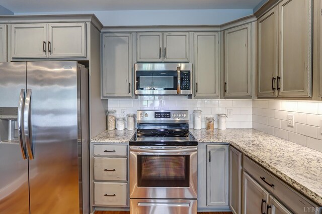 1013 Cobblestone Ln, Forest, VA 24551 - kitchen with appliances with stainless steel finishes, gray cabinets, light stone countertops, and decorative backsplash