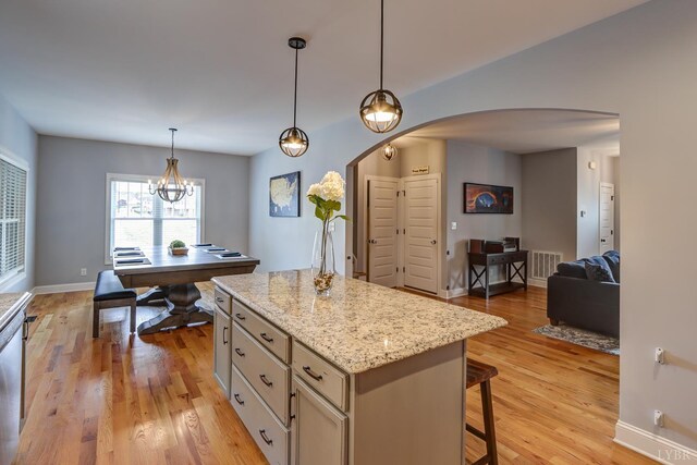 1013 Cobblestone Ln, Forest, VA 24551 - kitchen featuring arched walkways, open floor plan, a breakfast bar, light wood-type flooring, and a center island