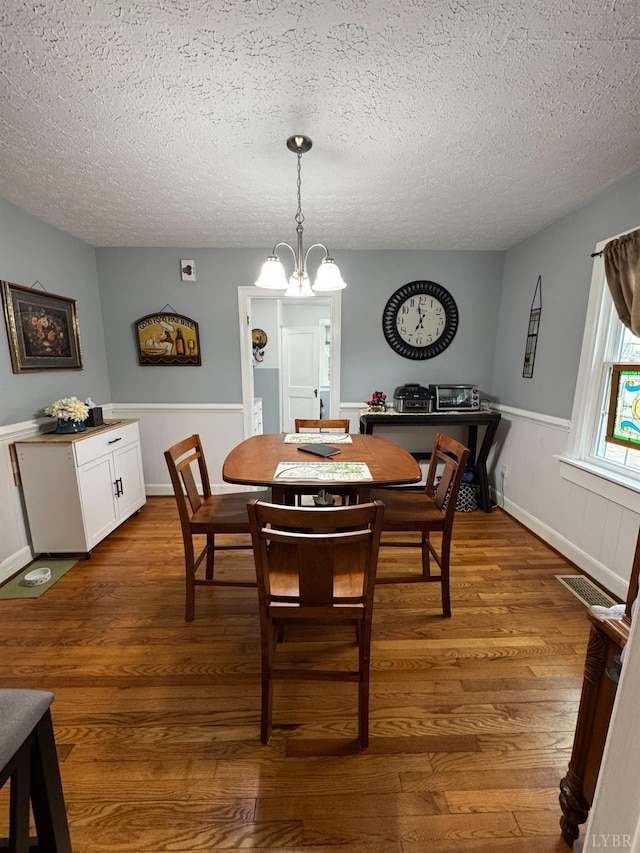 100 New Chapel Rd, Rustburg, VA 24588 - dining room with dark wood-style floors, a textured ceiling, a chandelier, and a wainscoted wall