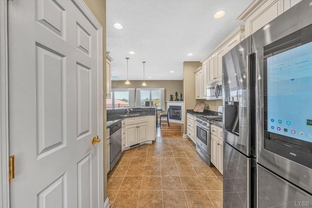 1066 Siesta Key Ct, Moneta, VA 24121 - kitchen with stainless steel appliances, dark countertops, a peninsula, decorative light fixtures, and a sink