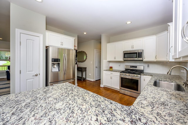 1032 Wiggington Rd, Lynchburg, VA 24502 - kitchen with appliances with stainless steel finishes, light stone counters, white cabinets, dark wood-type flooring, and recessed lighting