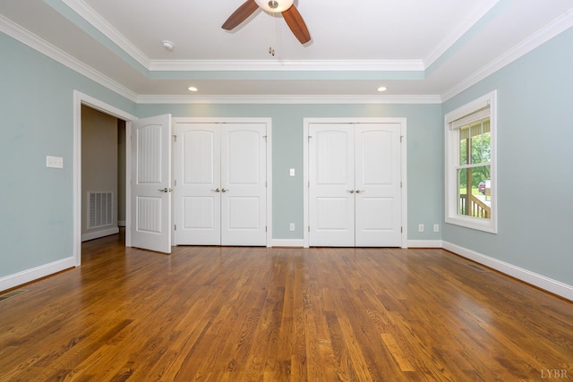 1032 Wiggington Rd, Lynchburg, VA 24502 - unfurnished bedroom featuring two closets, wood finished floors, crown molding, recessed lighting, and a tray ceiling