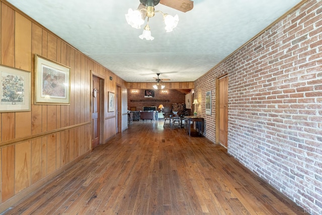 1094 Pigeon Run Rd, Gladys, VA 24554 - kitchen with ceiling fan, hardwood / wood-style flooring, brick wall, and wooden walls