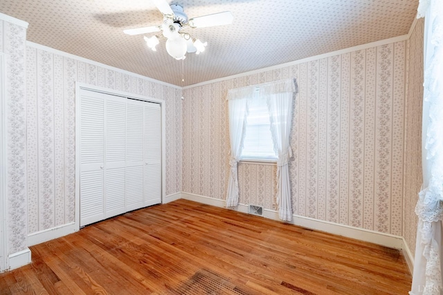 1094 Pigeon Run Rd, Gladys, VA 24554 - unfurnished bedroom featuring wood finished floors, ornamental molding, ceiling fan, baseboards, and a closet