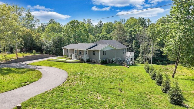 1620 Stripers Cove Rd, Goodview, VA 24095 - ranch-style home with covered porch, a front lawn, driveway, and a forest view
