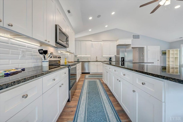 1620 Stripers Cove Rd, Goodview, VA 24095 - kitchen with appliances with stainless steel finishes, vaulted ceiling, ceiling fan, white cabinetry, and dark wood-type flooring