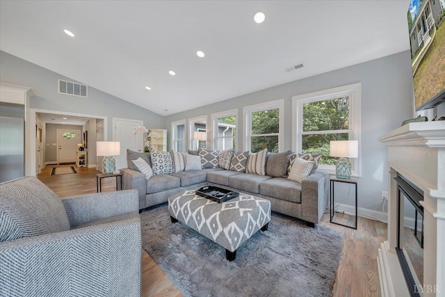 1620 Stripers Cove Rd, Goodview, VA 24095 - living area featuring vaulted ceiling, a glass covered fireplace, recessed lighting, light wood-style floors, and baseboards