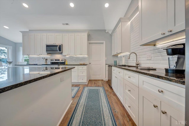 1620 Stripers Cove Rd, Goodview, VA 24095 - kitchen featuring appliances with stainless steel finishes, tasteful backsplash, light wood finished floors, white cabinetry, and recessed lighting