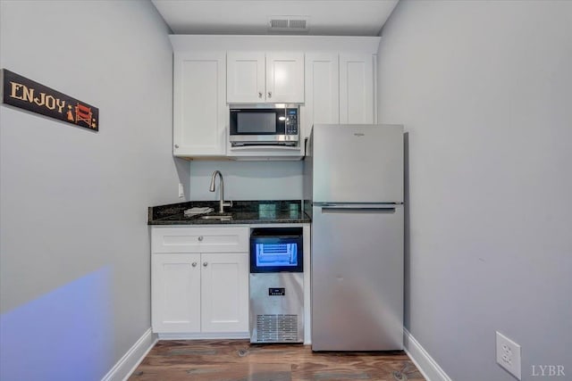1620 Stripers Cove Rd, Goodview, VA 24095 - kitchen featuring appliances with stainless steel finishes, white cabinets, a sink, and dark wood-style flooring
