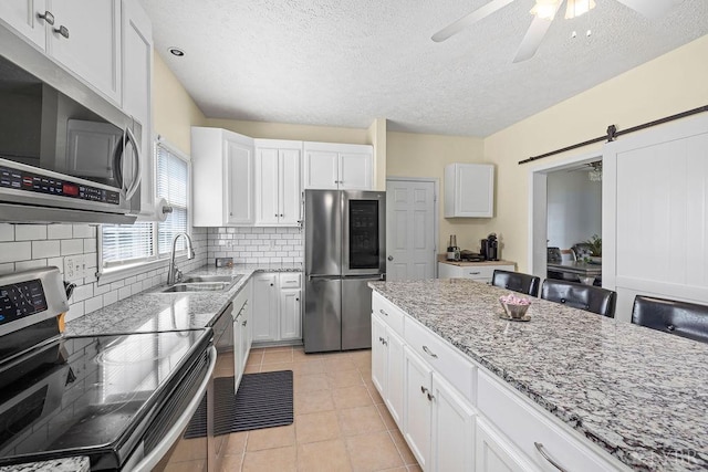 4710 Hummingbird Ln, Concord, VA 24538 - kitchen with stainless steel appliances, a sink, ceiling fan, light stone counters, and a textured ceiling