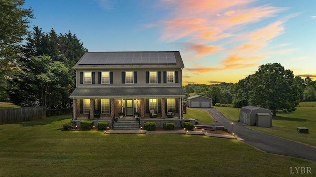 4710 Hummingbird Ln, Concord, VA 24538 - view of front of home featuring an outbuilding, a porch, a detached garage, solar panels, and brick siding