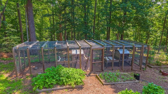 rear view of house with a vegetable garden, exterior structure, and an outbuilding