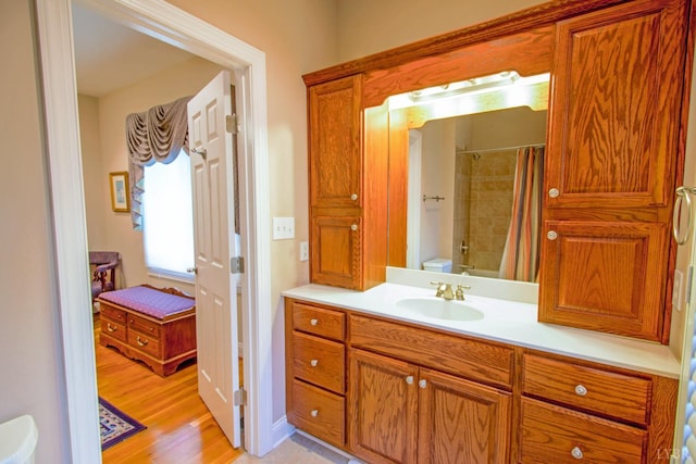 bathroom featuring vanity, curtained shower, and wood finished floors