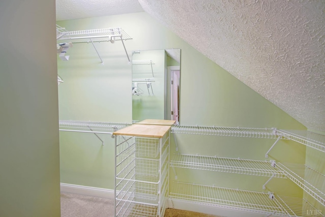 spacious closet featuring vaulted ceiling and carpet flooring